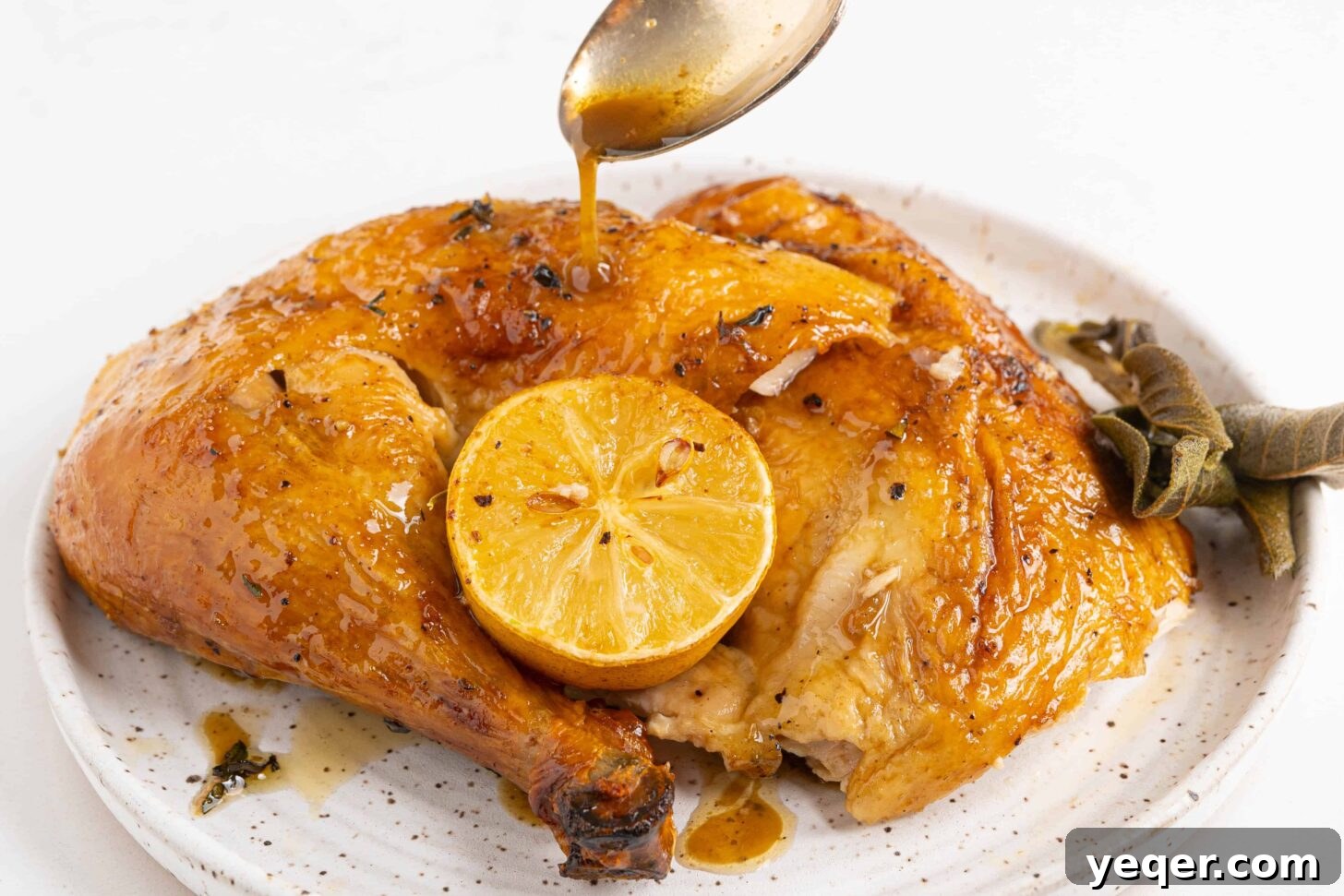 Succulent Golden Roast Chicken 7 A carved roasted chicken presented on a plate, drizzled with pan juices and garnished.