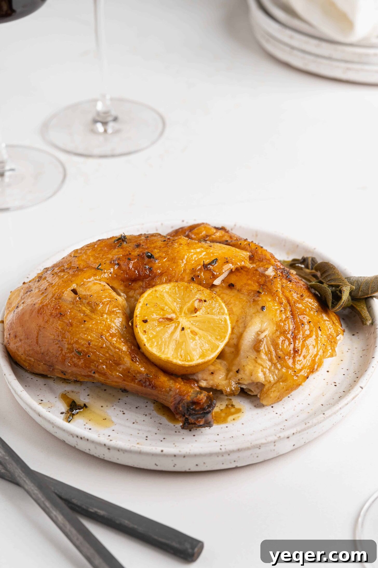 Succulent Golden Roast Chicken 9 A close-up of a carved roasted chicken piece on a white plate, ready to be served.