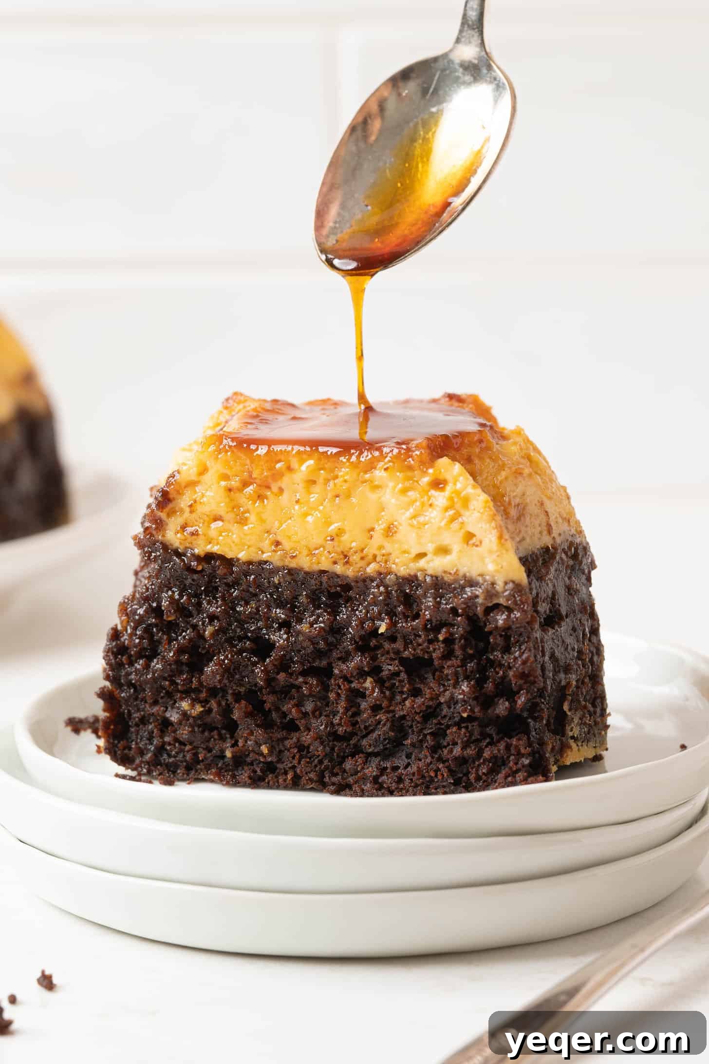 ChocoFlan A Culinary Illusion 2 A stunning slice of ChocoFlan on a white plate, showcasing its distinct layers of rich chocolate cake and creamy flan, topped with glossy caramel sauce.