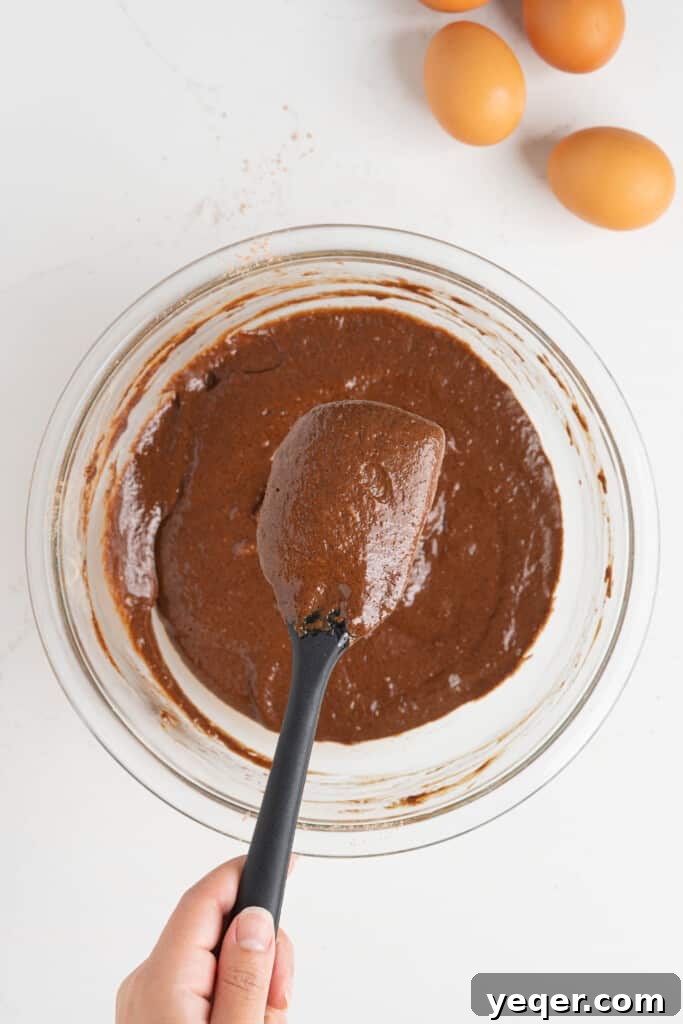 ChocoFlan A Culinary Illusion 6 A bowl filled with rich, dark chocolate cake batter, smooth and ready to be poured.