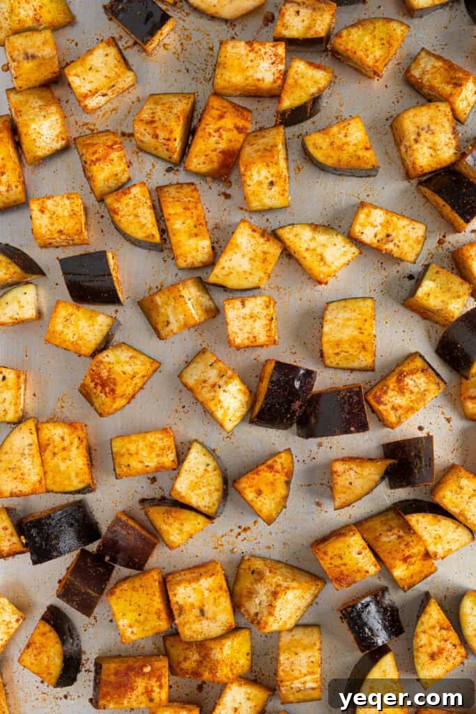 North African Roasted Aubergine in Minutes 5 Perfectly seasoned eggplant cubes spread out on a baking sheet, ready to be placed in the oven for roasting.