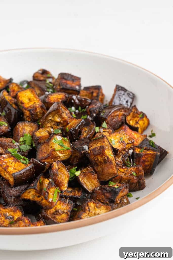 North African Roasted Aubergine in Minutes 6 A serving bowl filled with perfectly roasted Moroccan eggplant, garnished with fresh parsley and a delicate drizzle of tahini sauce.