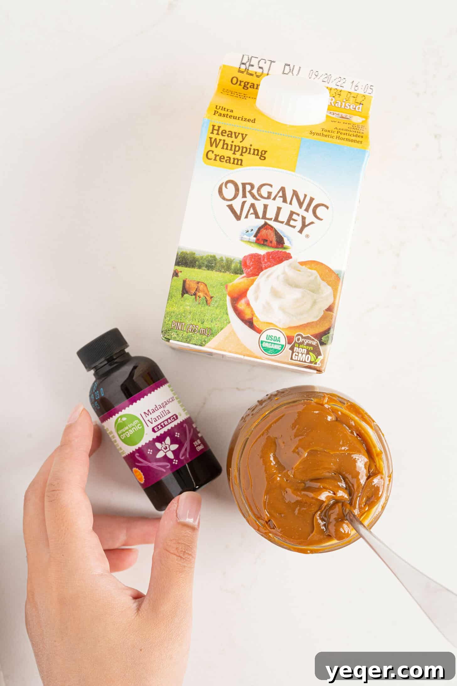 Three-Ingredient Bliss: Dulce de Leche Ice Cream 3 Ingredients laid out for making dulce de leche ice cream: heavy cream, vanilla extract, and a can of dulce de leche
