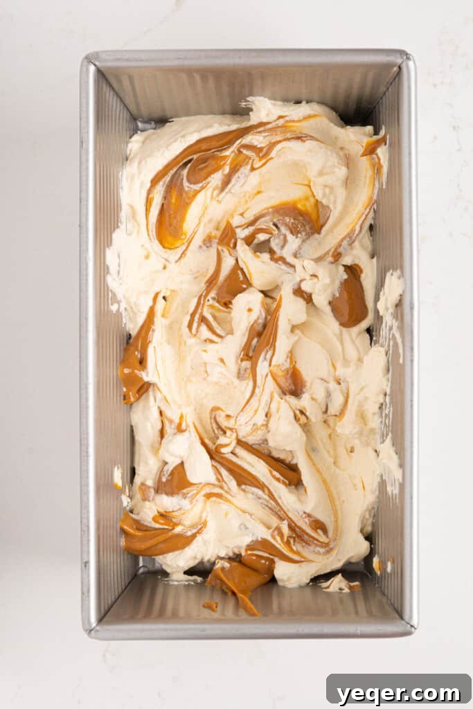 Three-Ingredient Bliss: Dulce de Leche Ice Cream 6 The initial layers of whipped cream mixture and dulce de leche in a loaf pan