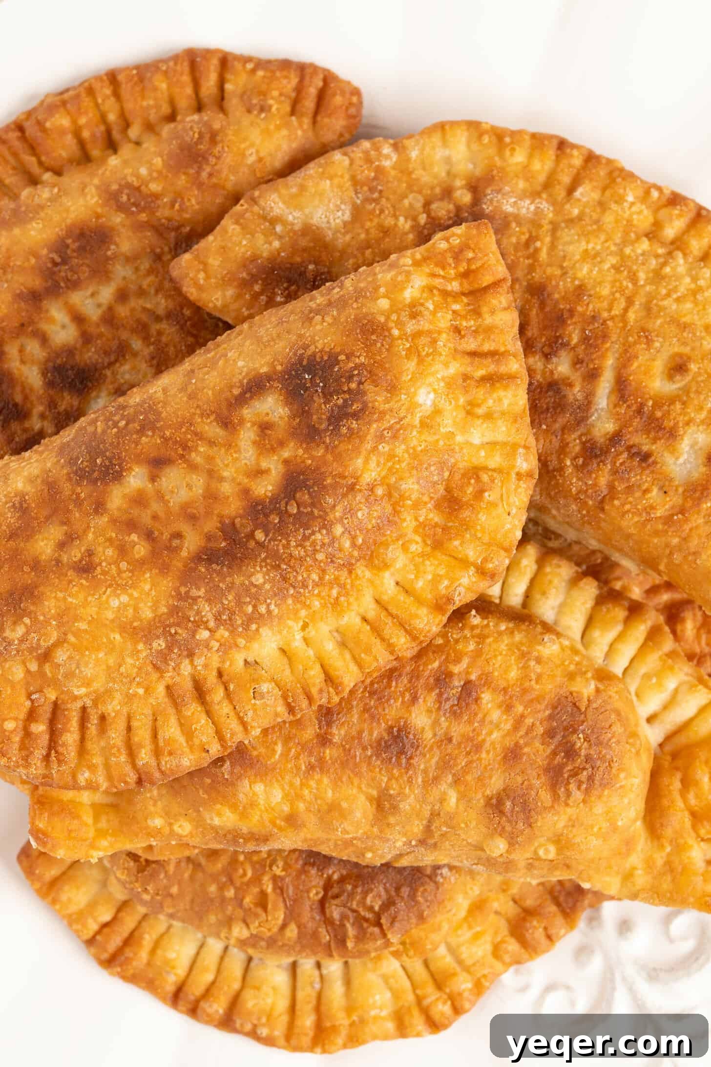 Five-Ingredient Wonder Empanada Dough 3 A selection of freshly baked golden-brown empanadas elegantly arranged on a serving plate, highlighting their crispy texture and delicious filling.