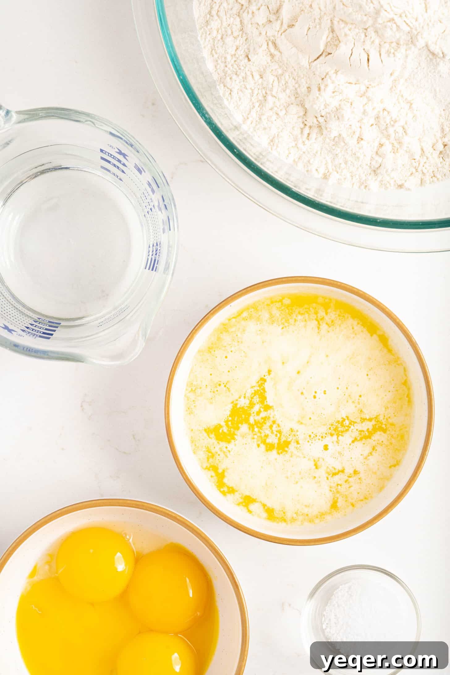 Five-Ingredient Wonder Empanada Dough 4 A clean, organized shot of the five essential ingredients laid out for making empanada dough: flour, butter, salt, eggs, and a glass of water, symbolizing simplicity and freshness.