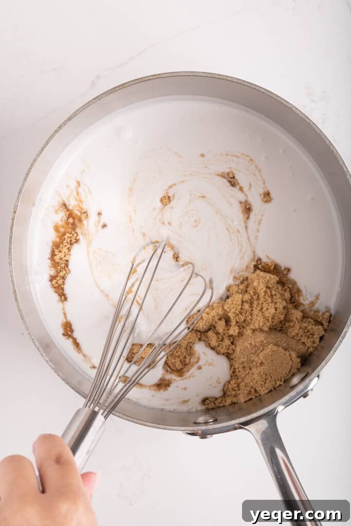 Velvety Vegan Coconut Caramel in 30 Minutes 5 A whisk stirring the coconut caramel mixture in a pot on a stovetop, as it begins to warm.