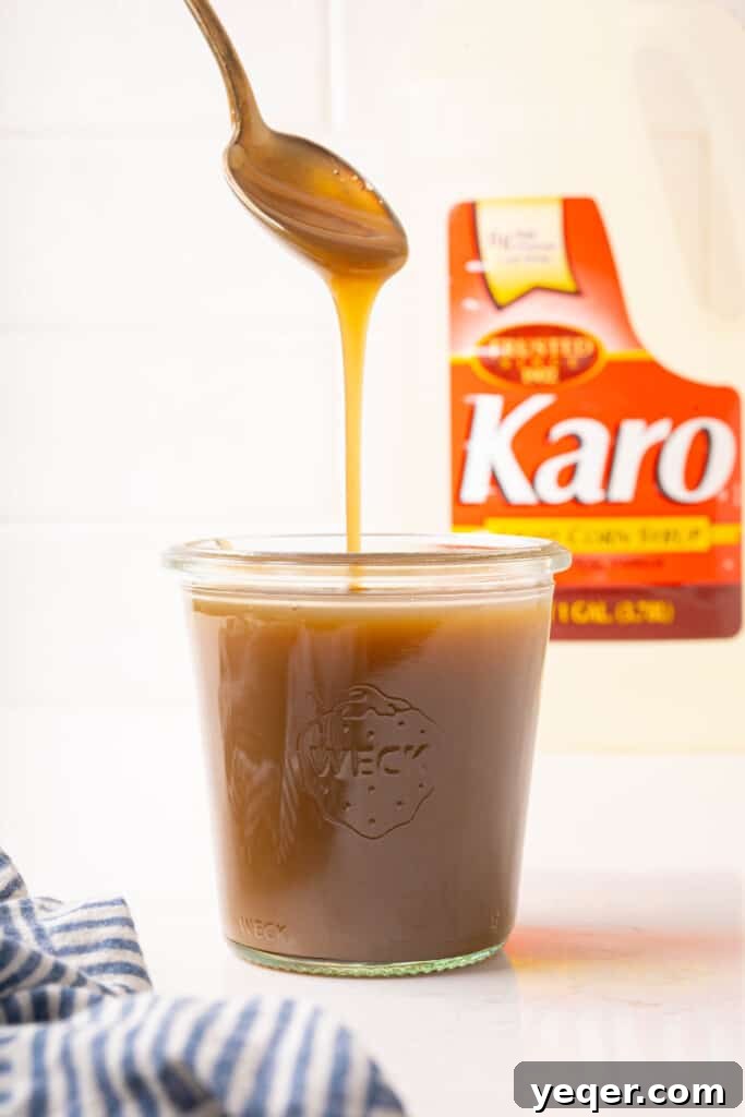 Velvety Vegan Coconut Caramel in 30 Minutes 7 Freshly made coconut caramel cooling in a glass jar on a wooden surface.