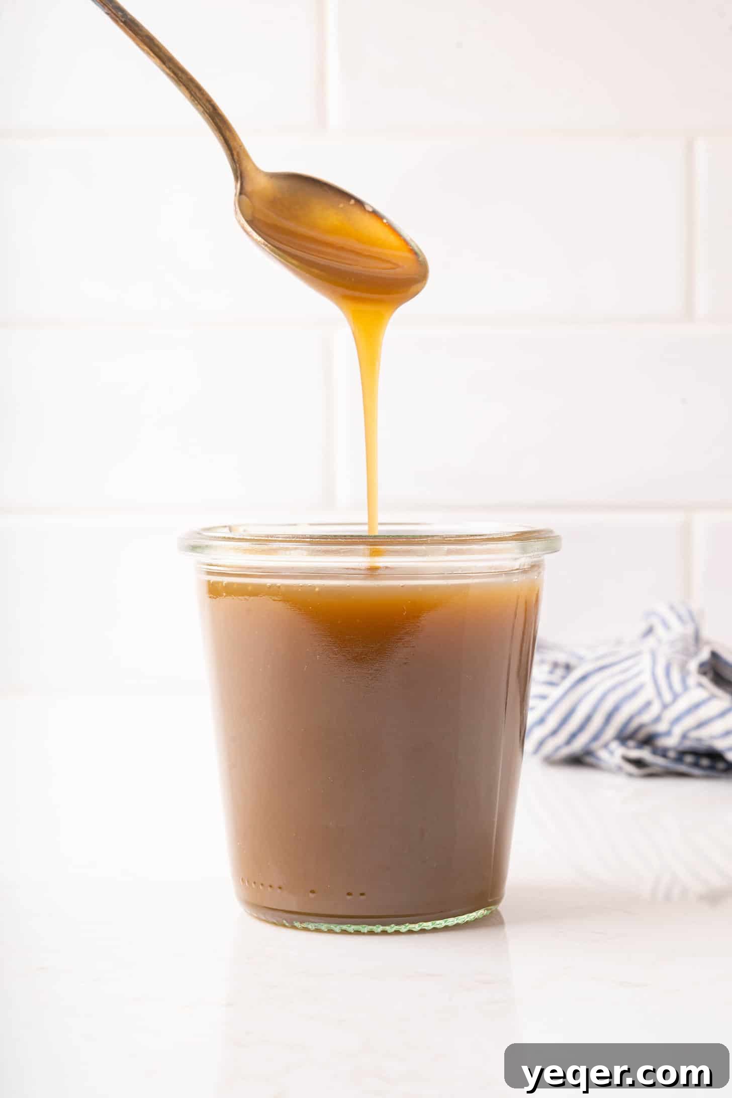 Velvety Vegan Coconut Caramel in 30 Minutes 8 A close-up of a jar filled with homemade coconut caramel sauce, highlighting its smooth, glossy texture.