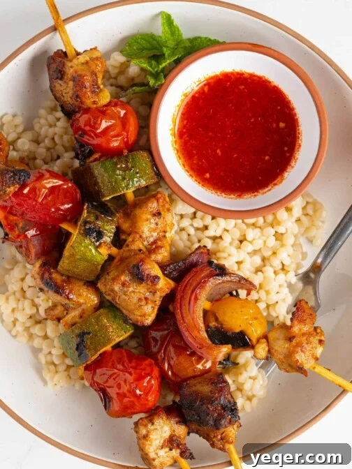 harissa chicken skewers on a plate of couscous