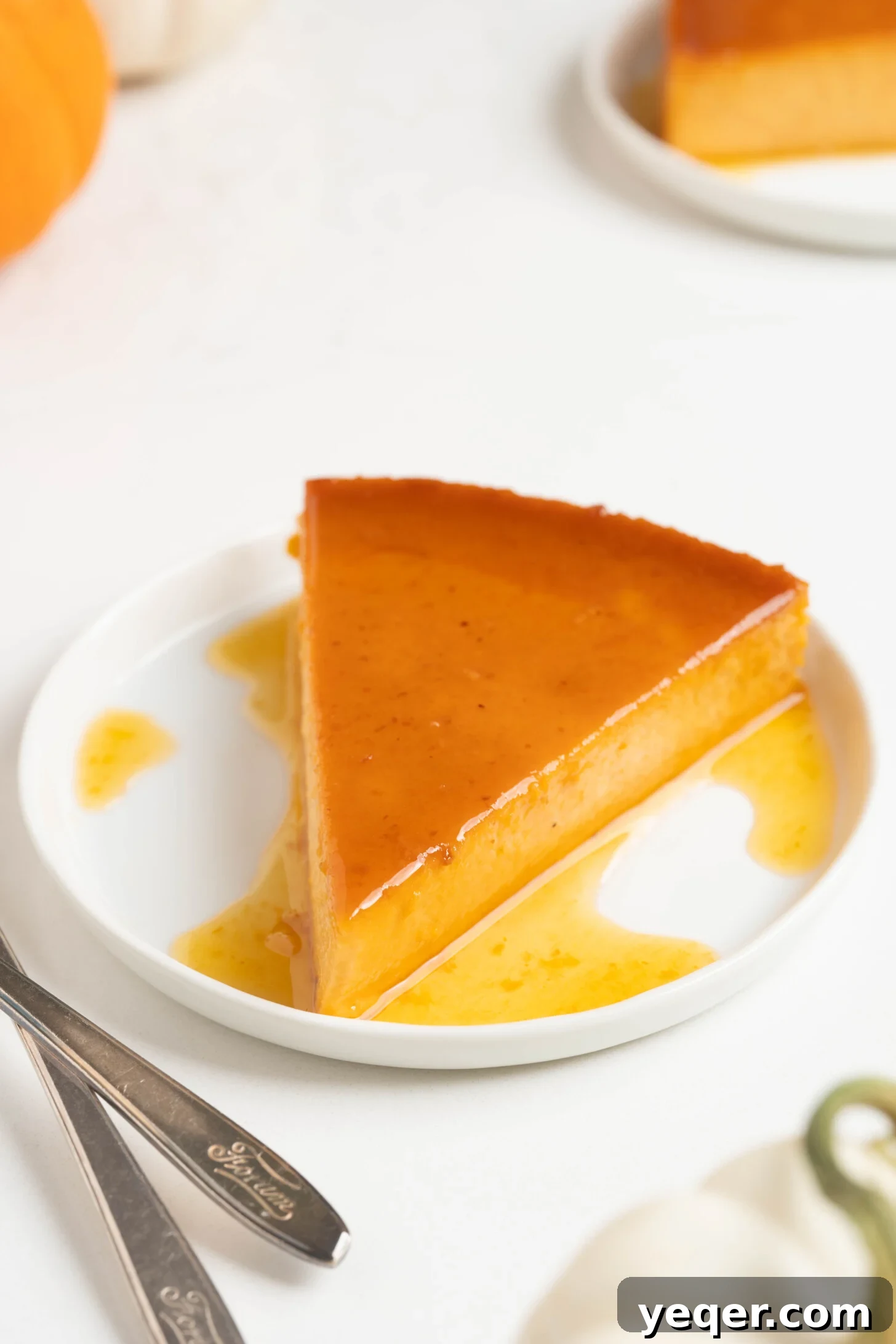 Golden Pumpkin Caramel Flan 2 Sliced pumpkin flan on a white plate, showcasing its creamy texture and caramel topping.