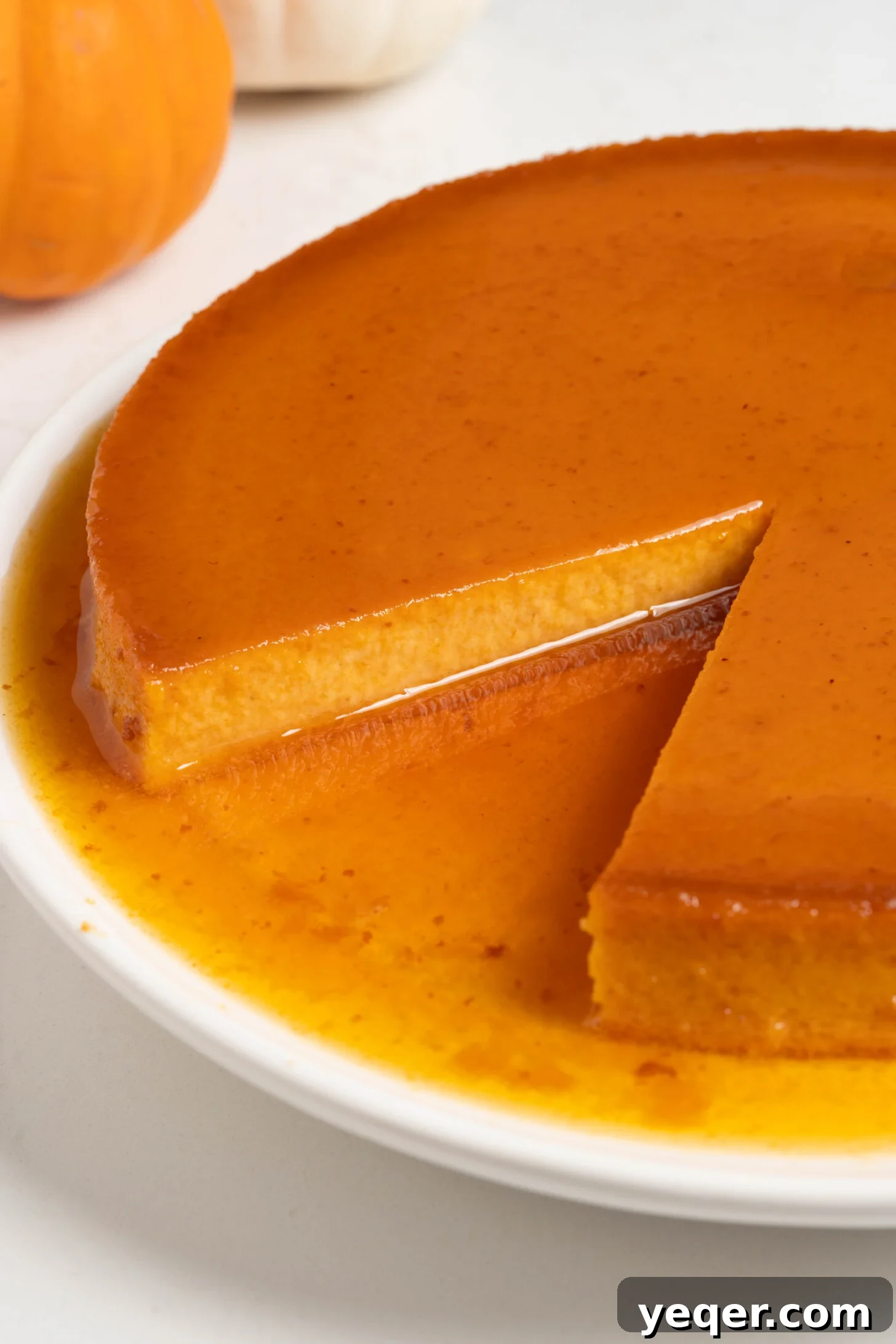 Golden Pumpkin Caramel Flan 14 Several slices of pumpkin flan artfully arranged on a long white plate, ready to be served.
