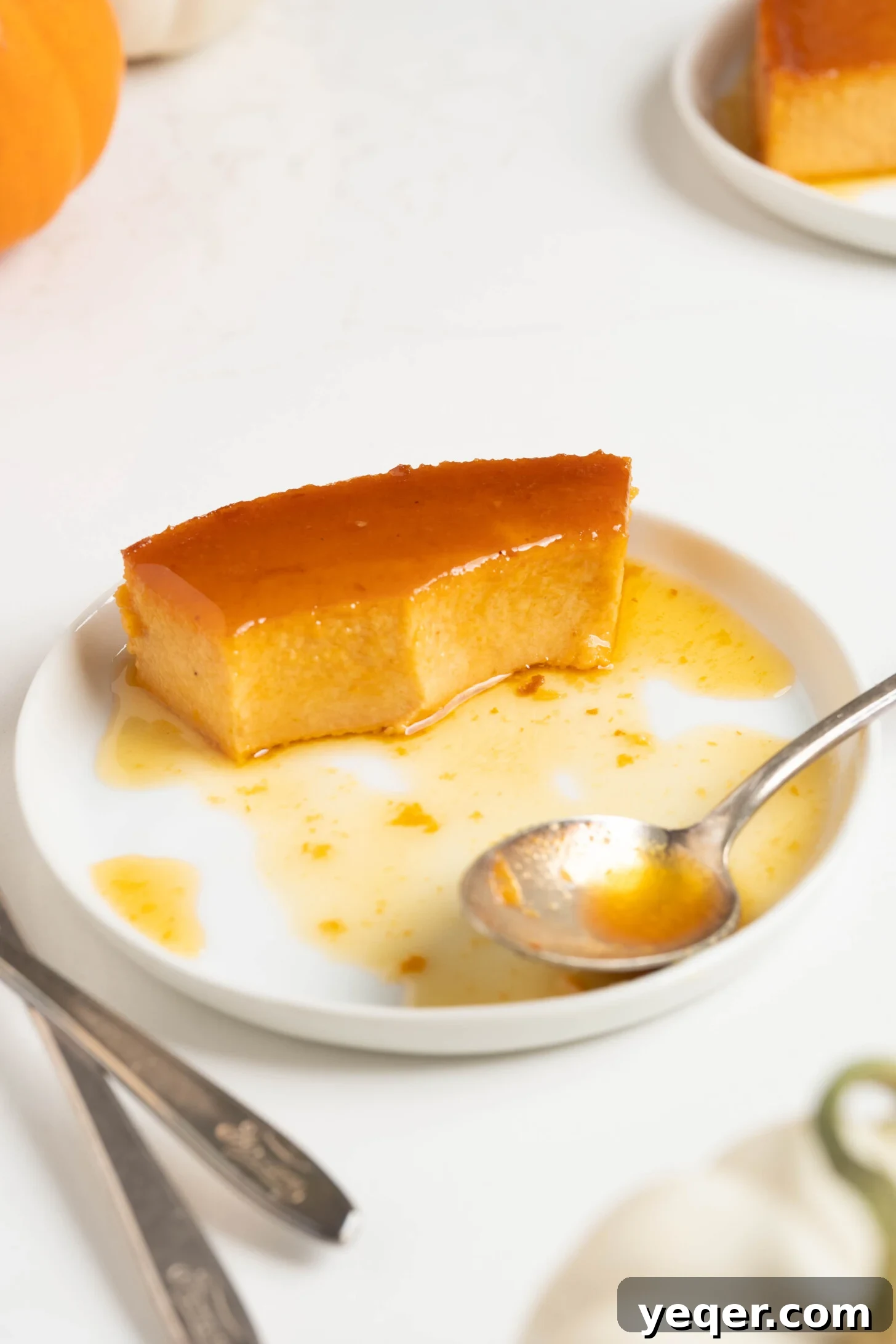 Golden Pumpkin Caramel Flan 15 A single slice of pumpkin flan with a rich caramel sauce, on a clean white plate.