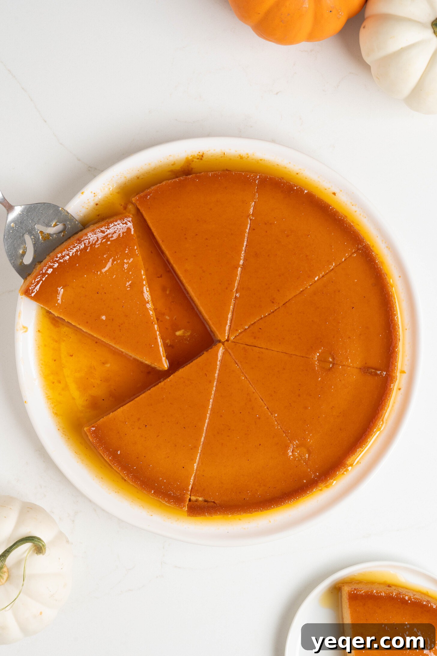 Golden Pumpkin Caramel Flan 3 A close-up of a perfectly sliced pumpkin flan with caramel sauce on a white plate.