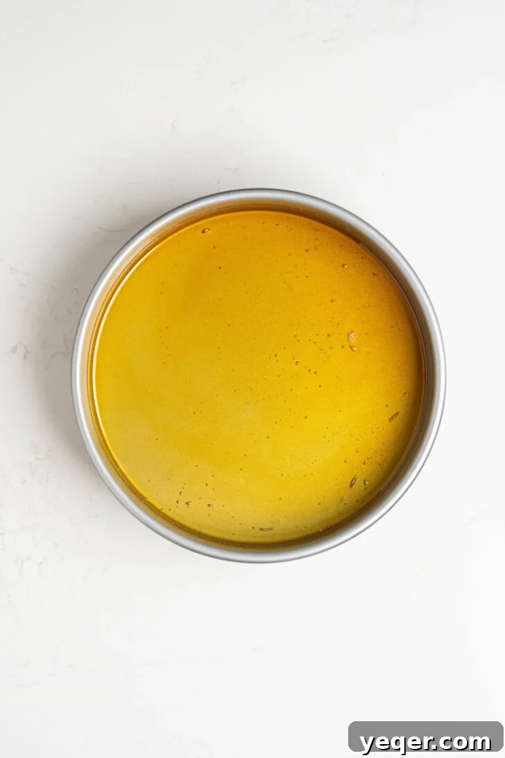 Golden Pumpkin Caramel Flan 7 Caramel evenly spread across the bottom of a baking dish.