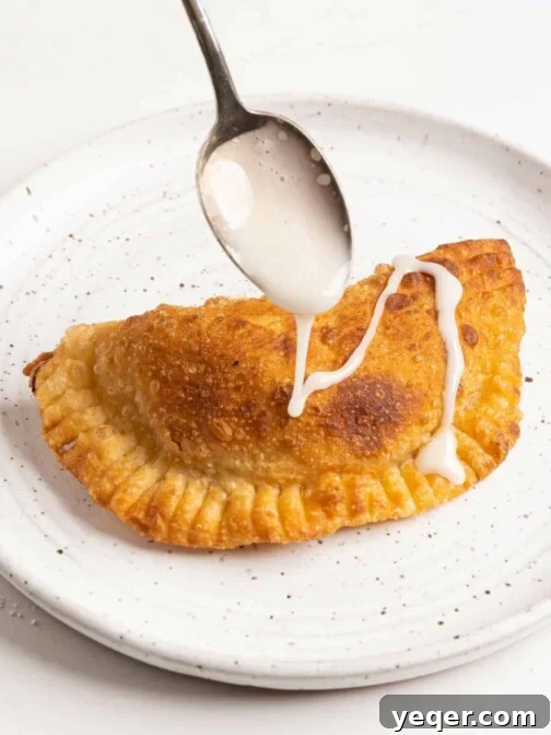 icing drizzling on apple empanadas