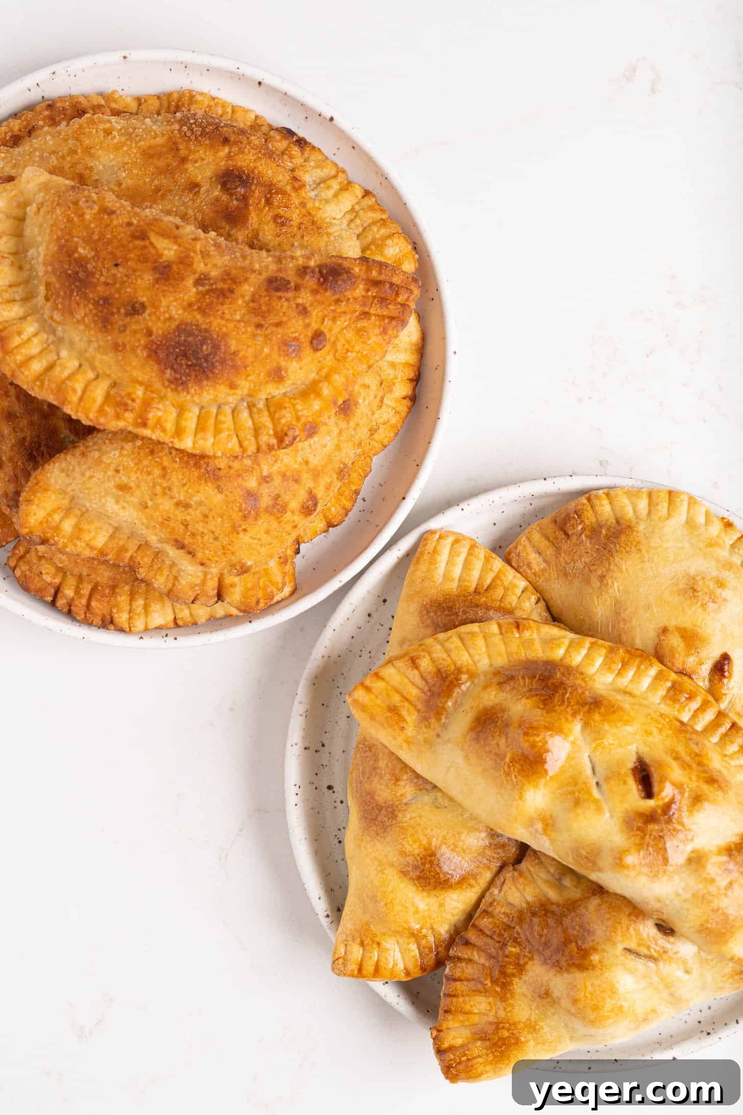 Golden Apple Pastry Pockets 10 A side-by-side comparison of baked and fried apple empanadas on separate plates, highlighting their different textures.