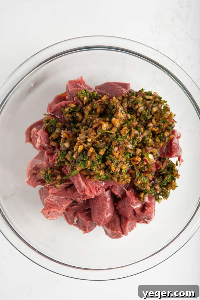 Char-Grilled Lamb Skewers with Tangy Preserved Lemon 5 Cubed lamb soaking in a rich, herb and spice-filled Moroccan marinade in a bowl.
