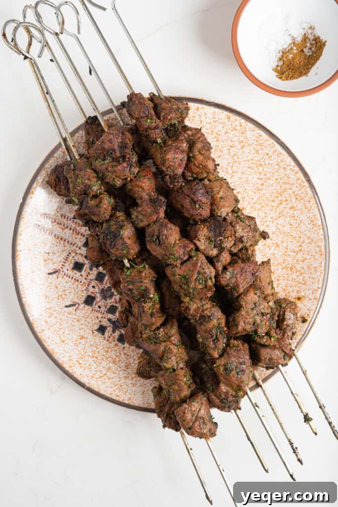 Char-Grilled Lamb Skewers with Tangy Preserved Lemon 7 Several grilled lamb kebabs resting on a plate, showing a perfect char and juicy interior.