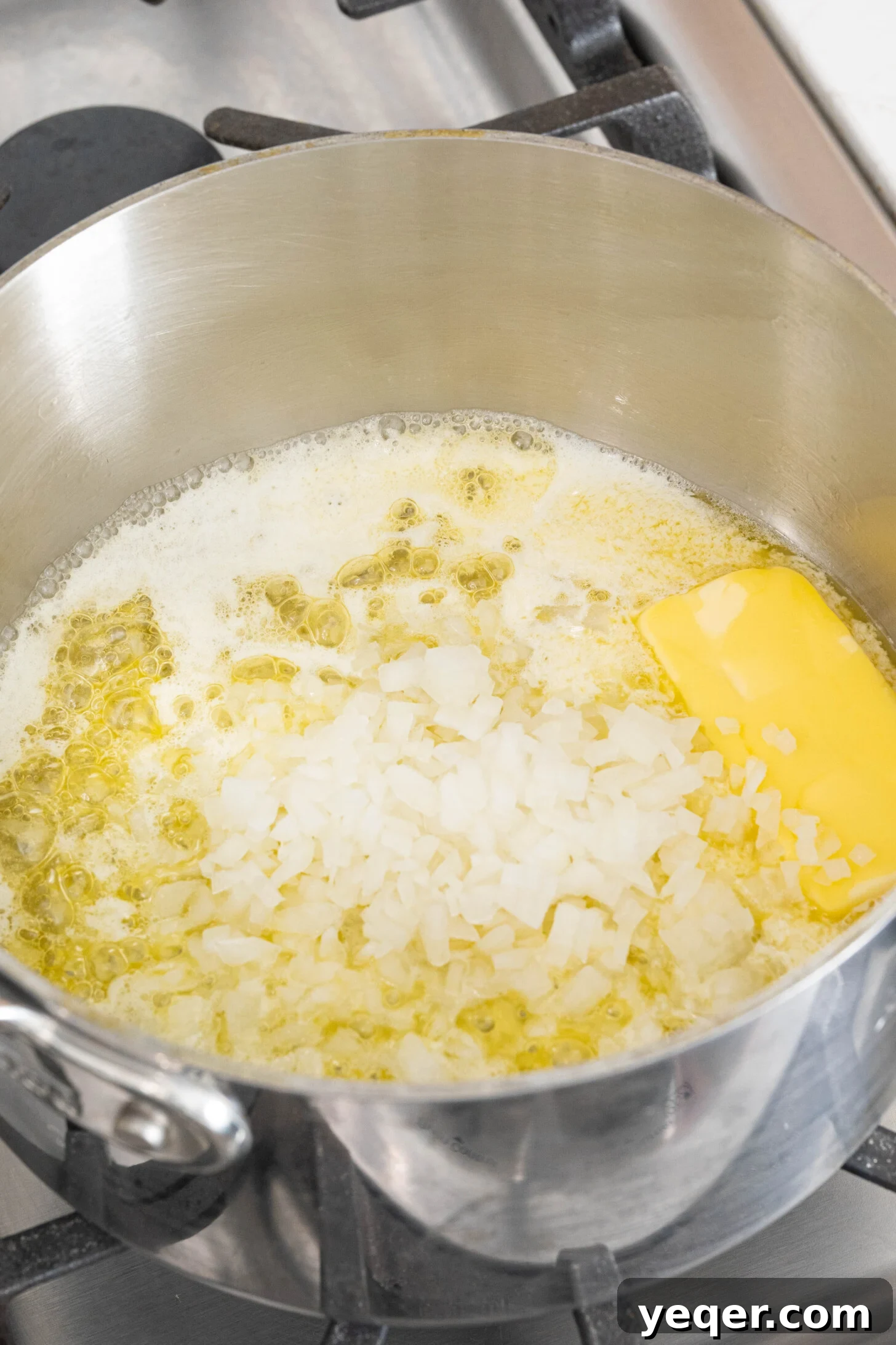 Golden Ham Croquettes 5 Diced onions being sautéed in melted butter in a pot, the first step in creating the rich béchamel filling for croquetas.
