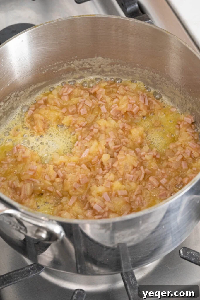 Golden Ham Croquettes 6 The roux, a mixture of butter, flour, diced ham, and onions, being prepared in a pot before the milk is added for the béchamel sauce.