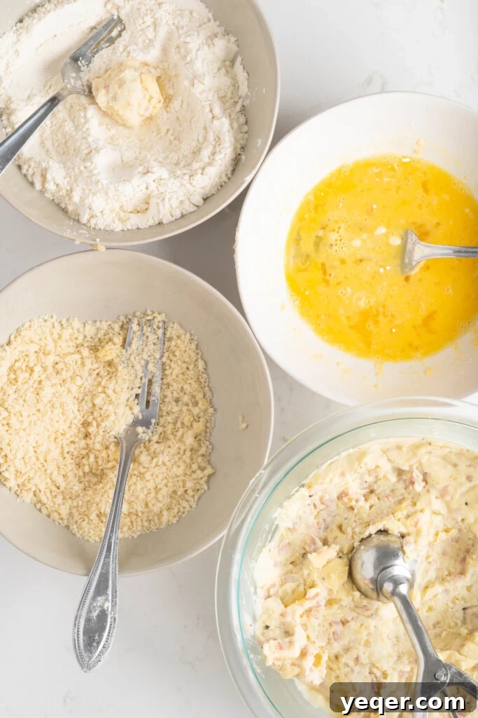 Golden Ham Croquettes 9 A breading station set up with bowls of flour, breadcrumbs, and beaten eggs, ready for coating the croquetas.