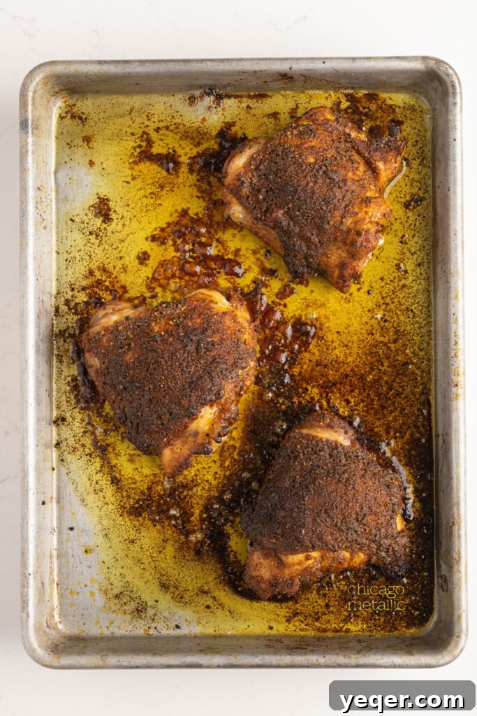 Effortless Ras El Hanout Chicken Thighs Three Ingredients 6 Beautifully seasoned chicken thighs, coated in Ras el Hanout, are arranged on a baking pan, ready to be roasted to perfection.