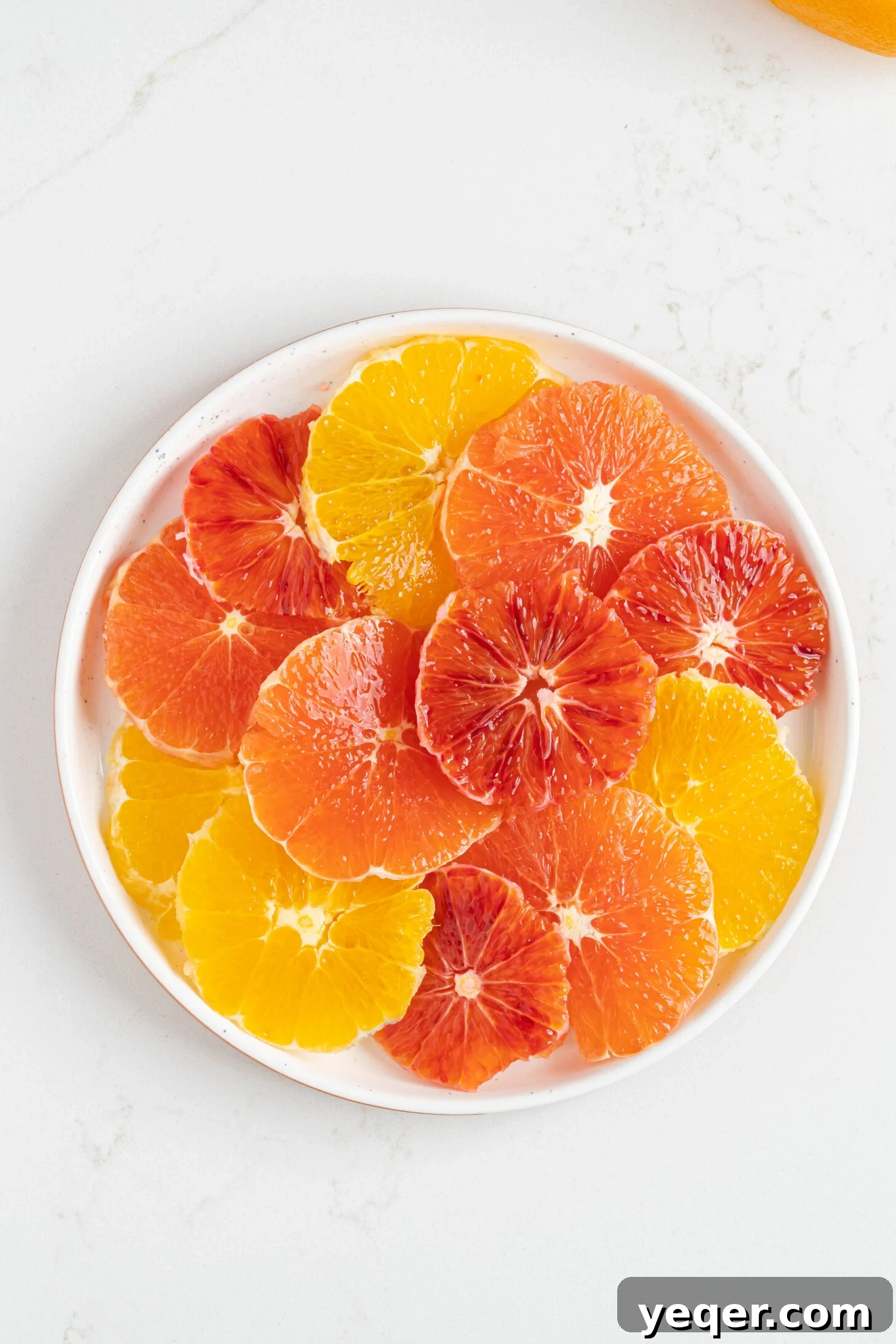 Quick Moroccan Orange Salad with Cinnamon Spice 8 Close-up of perfectly sliced oranges arranged on a white plate, ready for dressing.