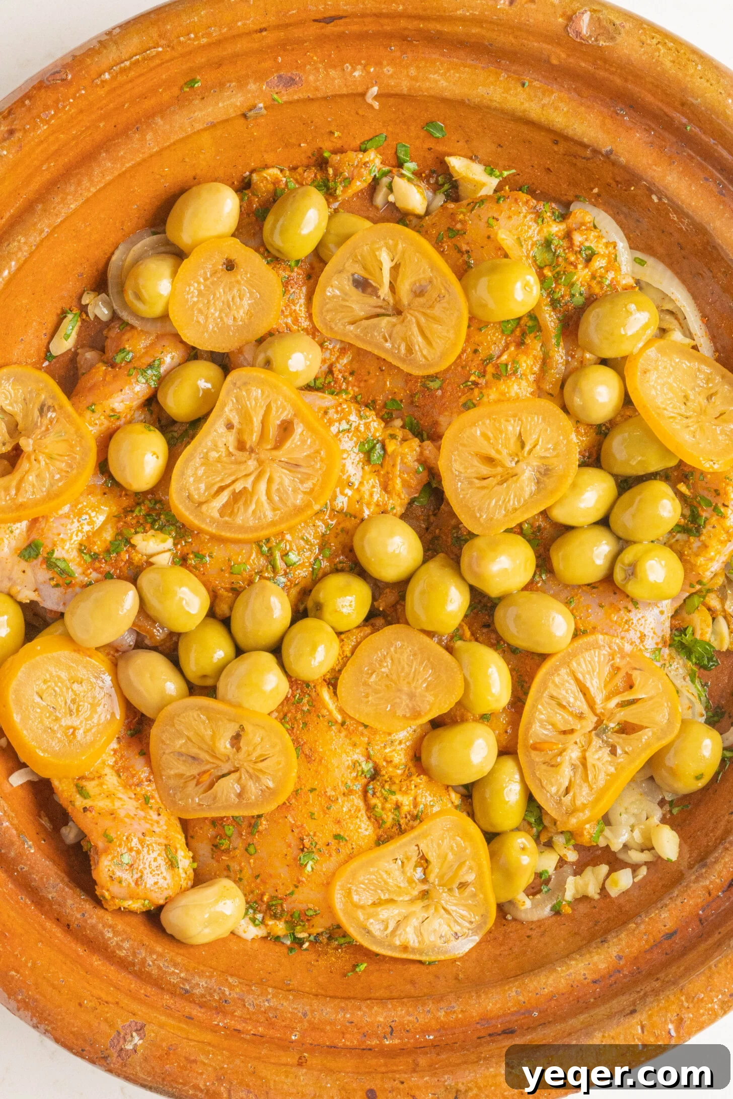 Unveiling the Moroccan Art of Tagine Service 6 An uncooked chicken tagine, beautifully arranged with vibrant olives and bright lemon slices, showcasing the fresh ingredients before cooking.