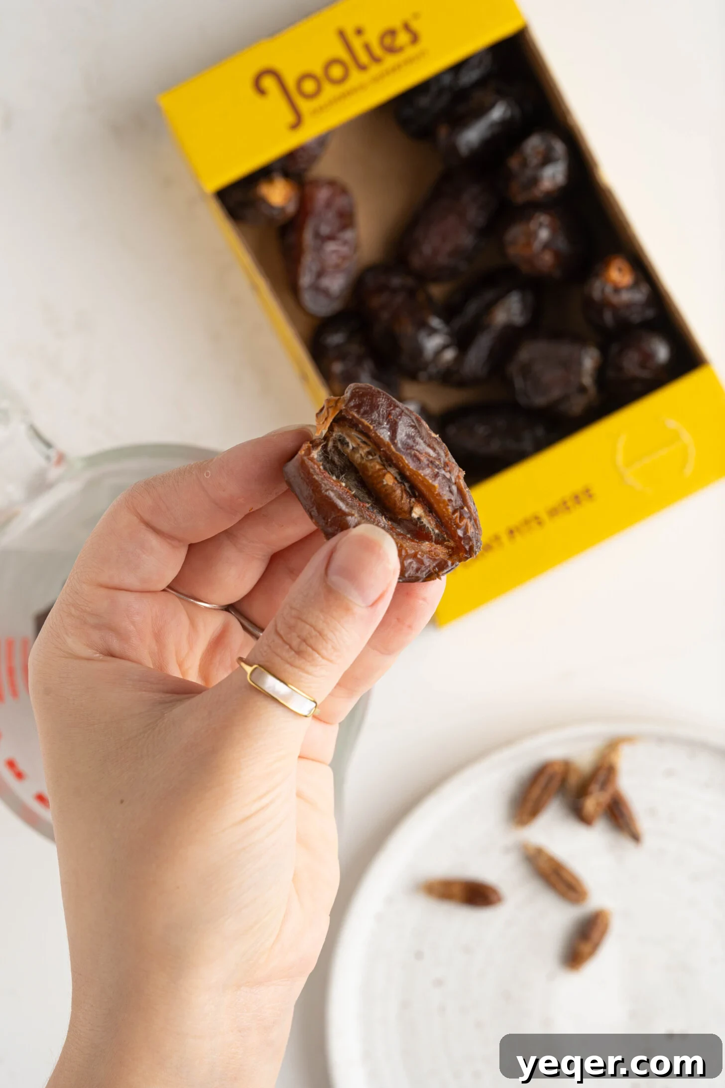 Pure Date Nectar 14 A hand carefully removing a pit from a date
