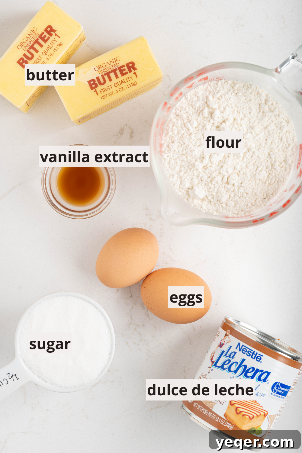 Easy Dulce de Leche Thumbprint Cookies 3 Bowls of flour, sugar, and sticks of softened butter, alongside eggs and vanilla extract, ready for baking Dulce de Leche cookies.