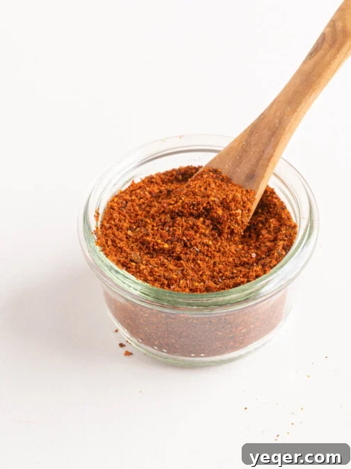 Homemade paprika in a small jar with a wooden spoon