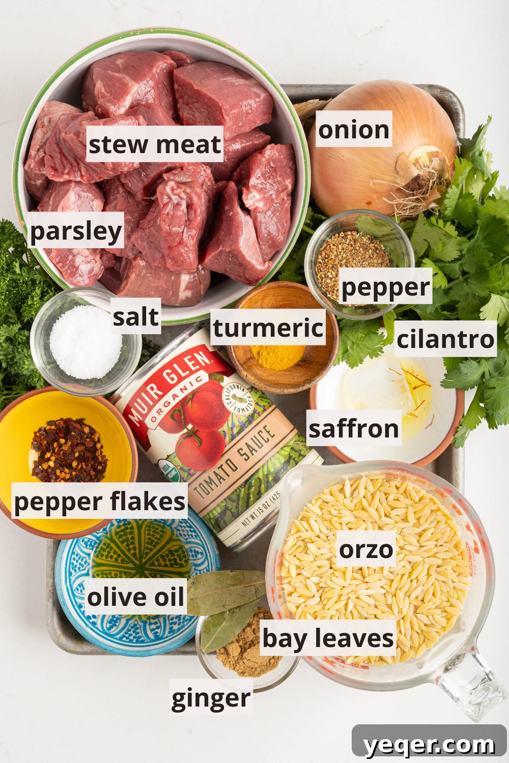 Moroccan Lamb Orzo Pilaf 3 An array of ingredients laid out, including bowls of orzo, stew meat, various Moroccan spices, and fresh herbs, ready for cooking.