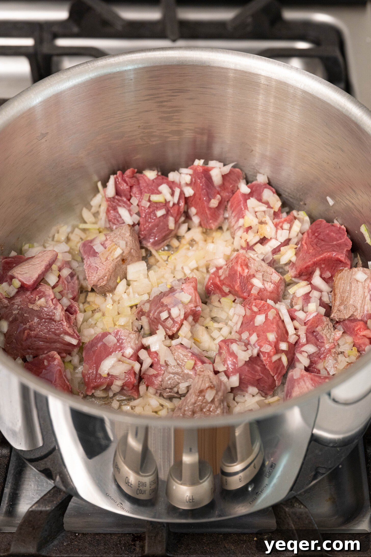 Moroccan Lamb Orzo Pilaf 4 A pot on a stovetop with cubed lamb or beef and minced onions sautéing in olive oil until golden brown.