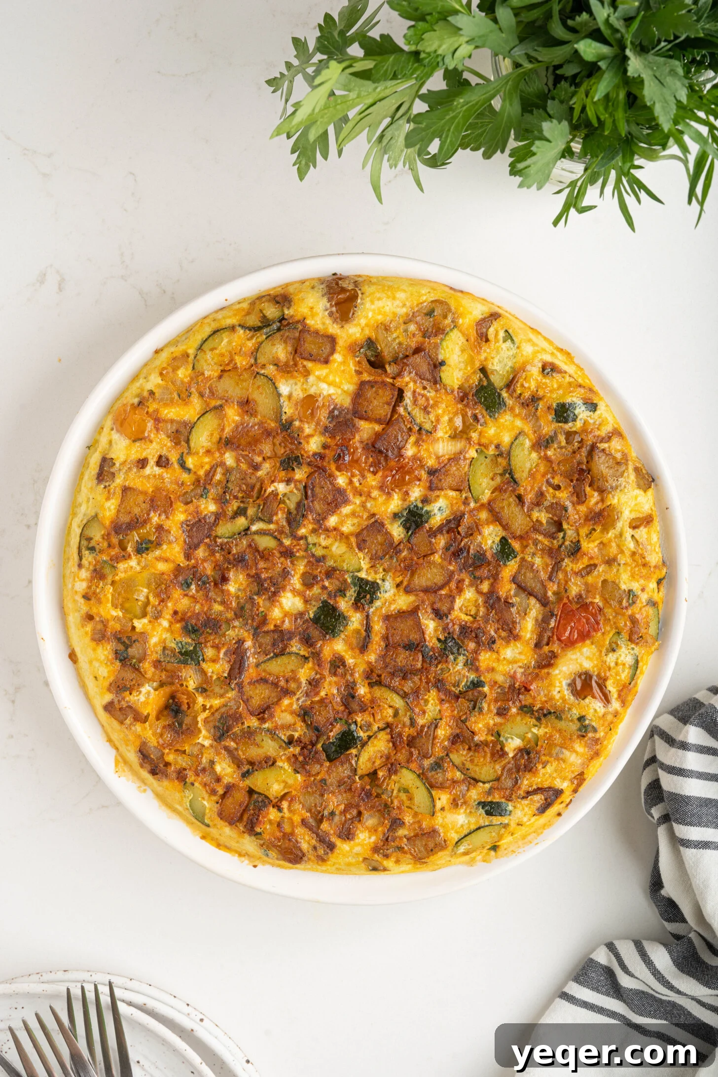 Moroccan Golden Potato Frittata 4 a perfectly cooked potato omelette resting on a white plate, ready to be sliced
