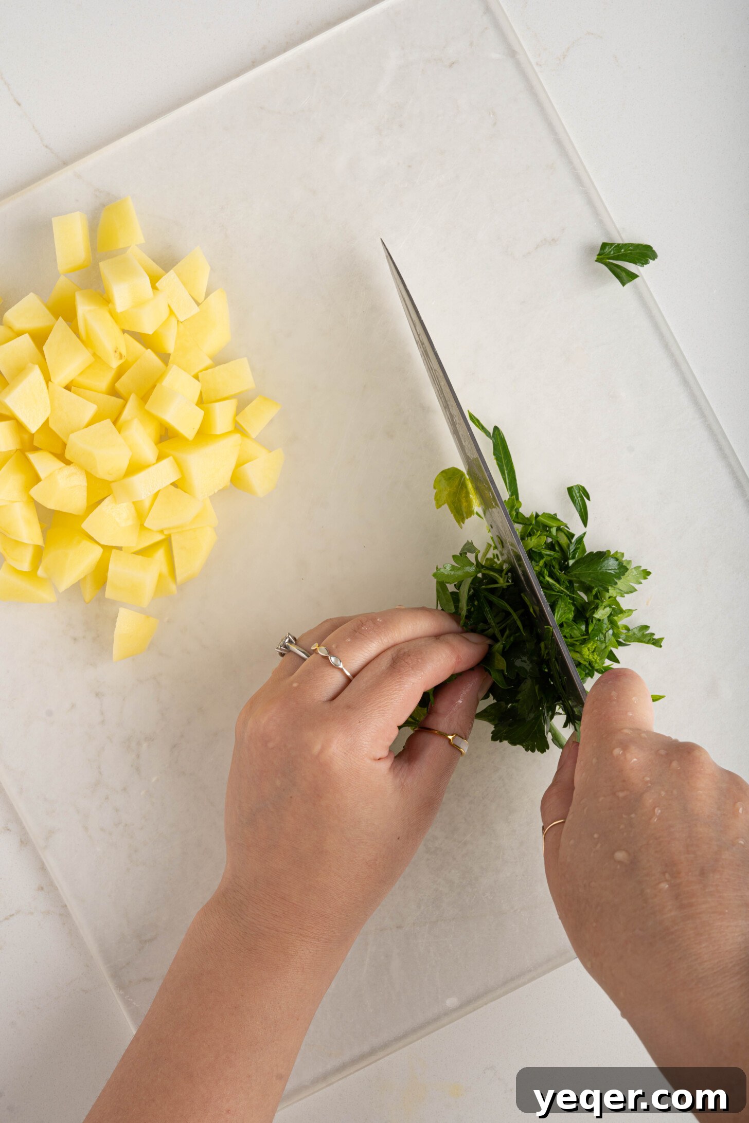 Moroccan Golden Potato Frittata 5 hands mincing fresh parsley on a cutting board, preparing ingredients for the omelette