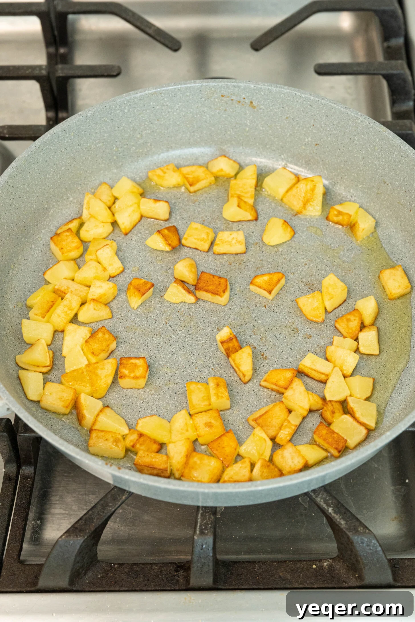 Moroccan Golden Potato Frittata 6 diced potatoes slowly browning in olive oil in a hot pan, starting to achieve a golden color