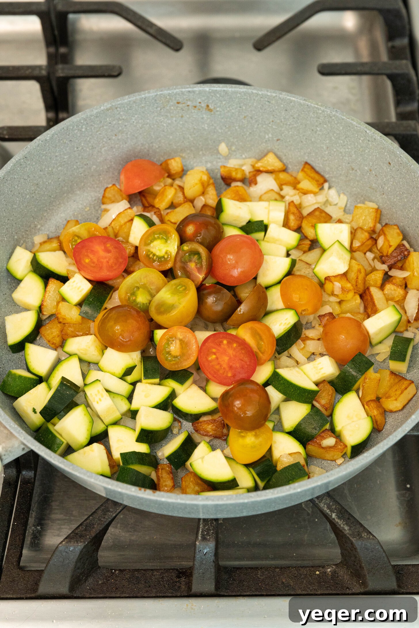 Moroccan Golden Potato Frittata 7 a colorful mix of zucchini, tomatoes, potatoes, and onions simmering together in a pan