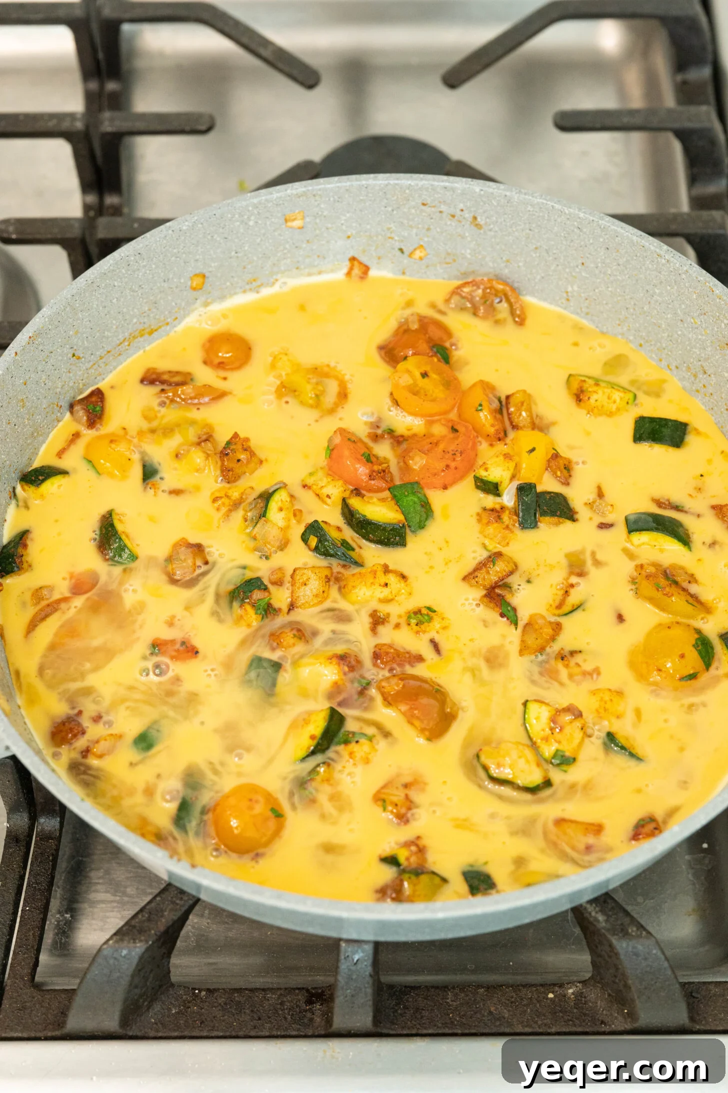 Moroccan Golden Potato Frittata 9 a raw omelette mixture in a pan with eggs just poured over the vegetables, before cooking