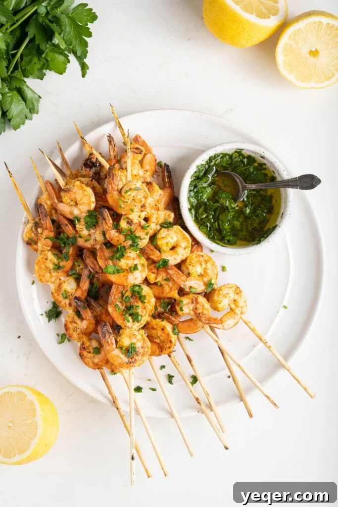 Simply Delicious 5 Ingredient Grilled Shrimp Skewers 8 A close-up shot of perfectly grilled shrimp skewers on a white plate, adorned with a vibrant sprinkle of fresh parsley.
