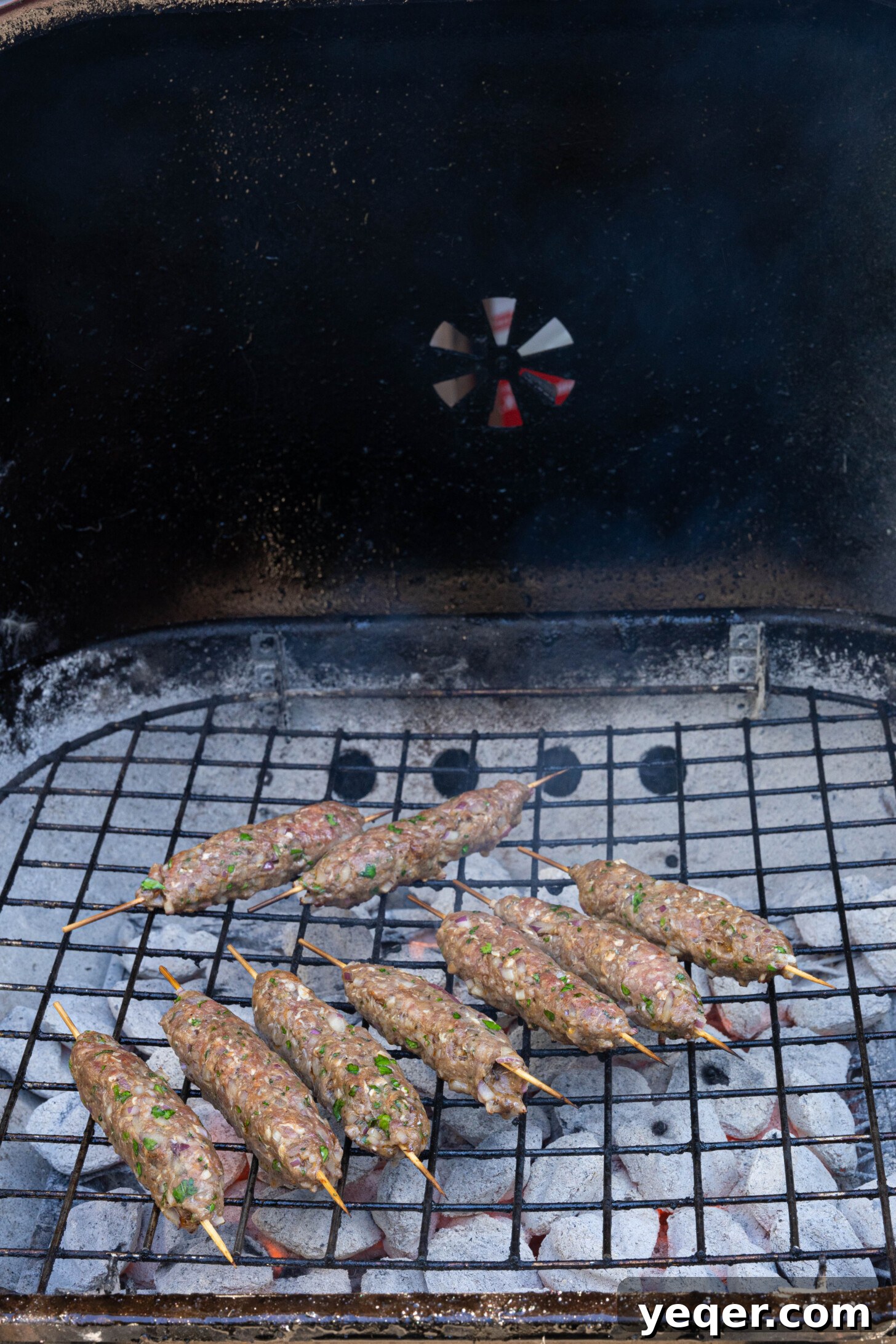 Sizzling Moroccan Kefta in 30 Minutes 7 Moroccan kefta skewers cooking on a hot grill, showing developing grill marks.