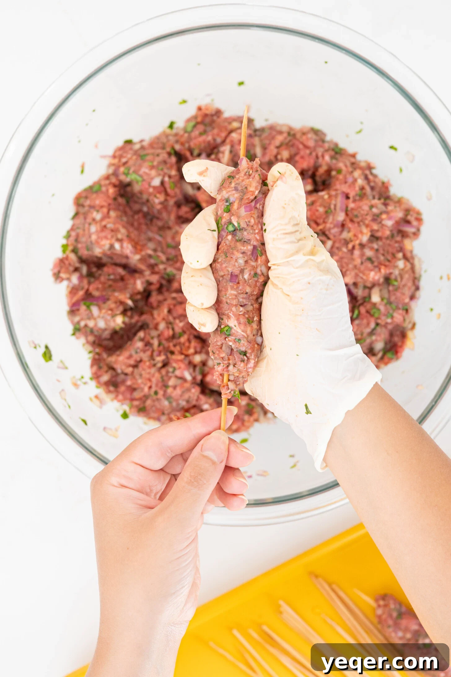 Sizzling Moroccan Kefta in 30 Minutes 10 Close-up of hands expertly molding ground kefta meat onto skewers, ready for grilling.