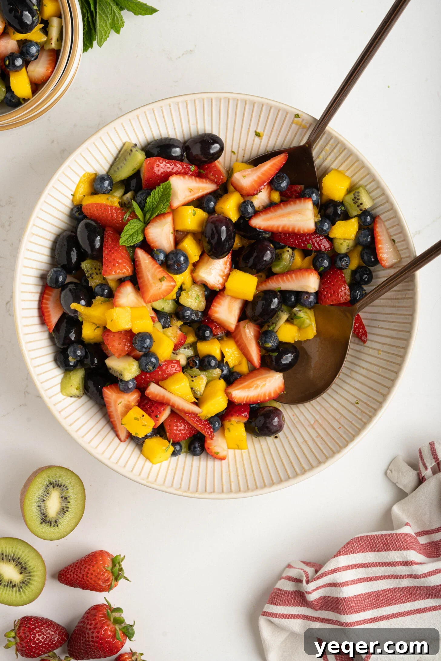 A classic fruit salad in a white bowl, freshly prepared and inviting, ready to be served.