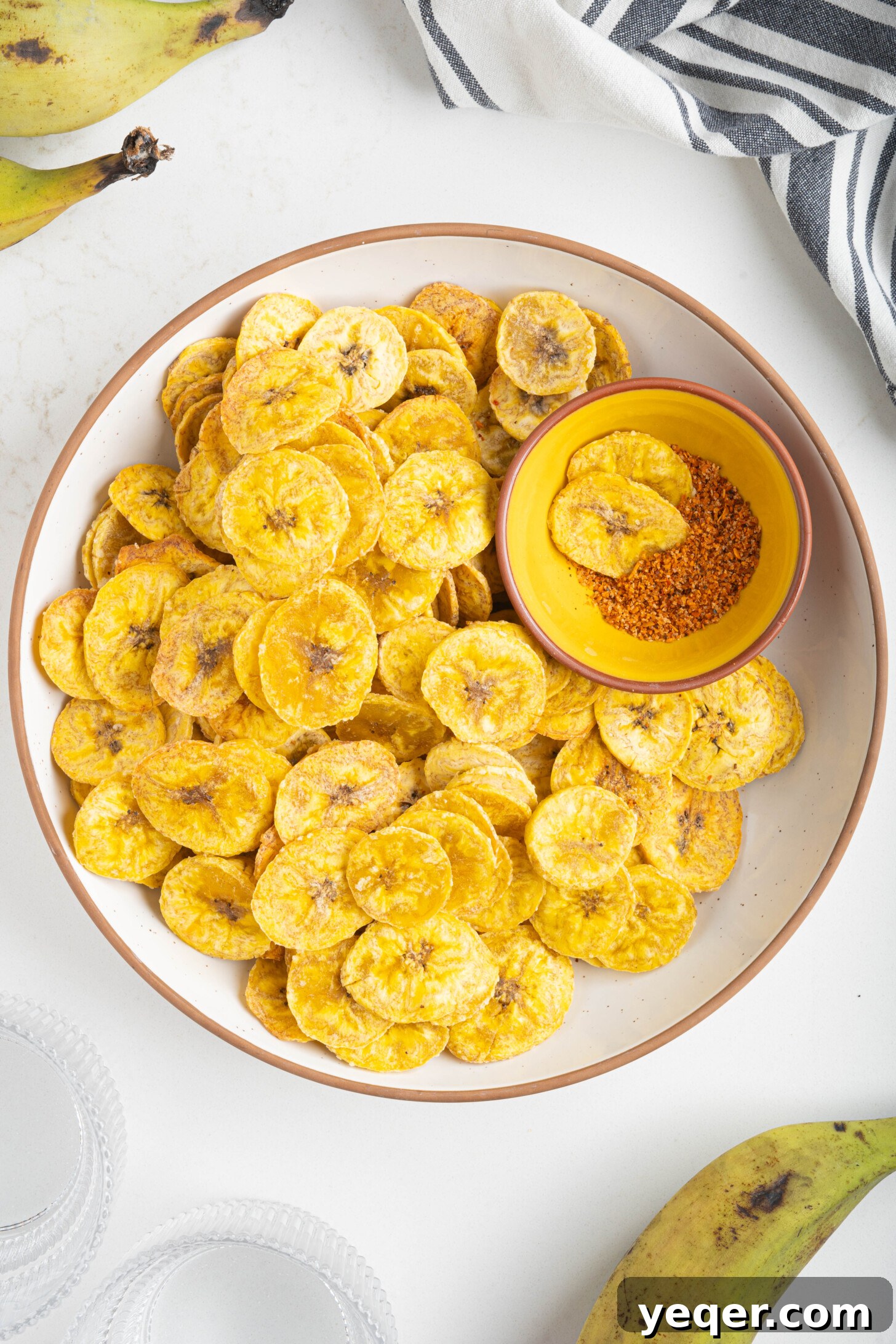Effortless Oven-Baked Plantain Crisps 11 A large bowl filled with an abundance of perfectly baked plantain chips, seasoned and ready to be served.