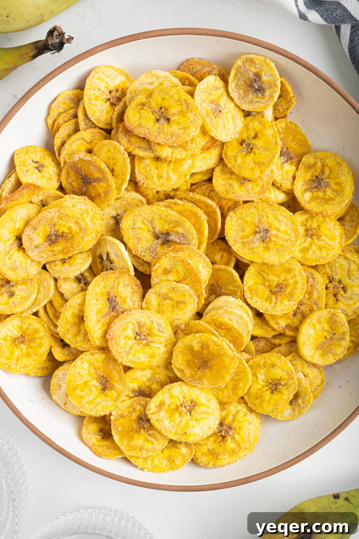 Effortless Oven-Baked Plantain Crisps 13 A large bowl filled with golden, crispy baked plantain chips.