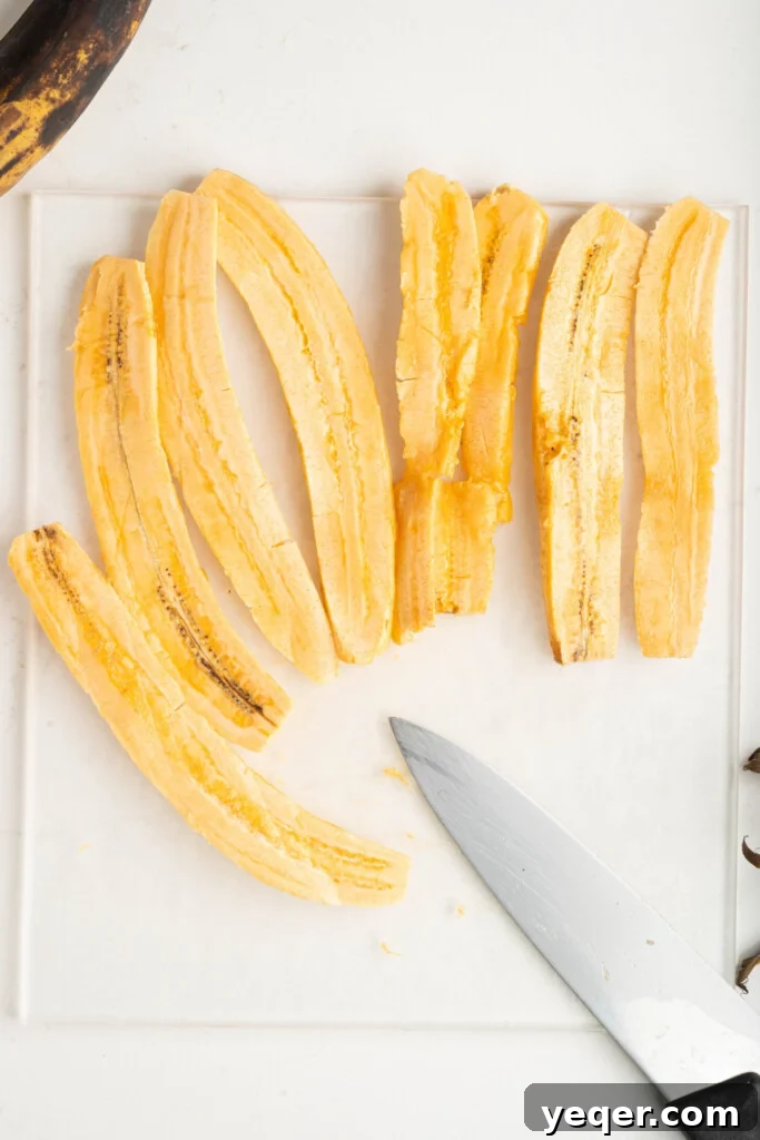 Puerto Rican Stuffed Plantain Cups 5 Sliced ripe plantains on a cutting board, ready for frying.