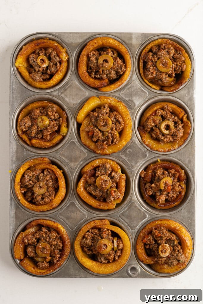 Puerto Rican Stuffed Plantain Cups 8 Muffin tin with assembled piononos, ready for baking.