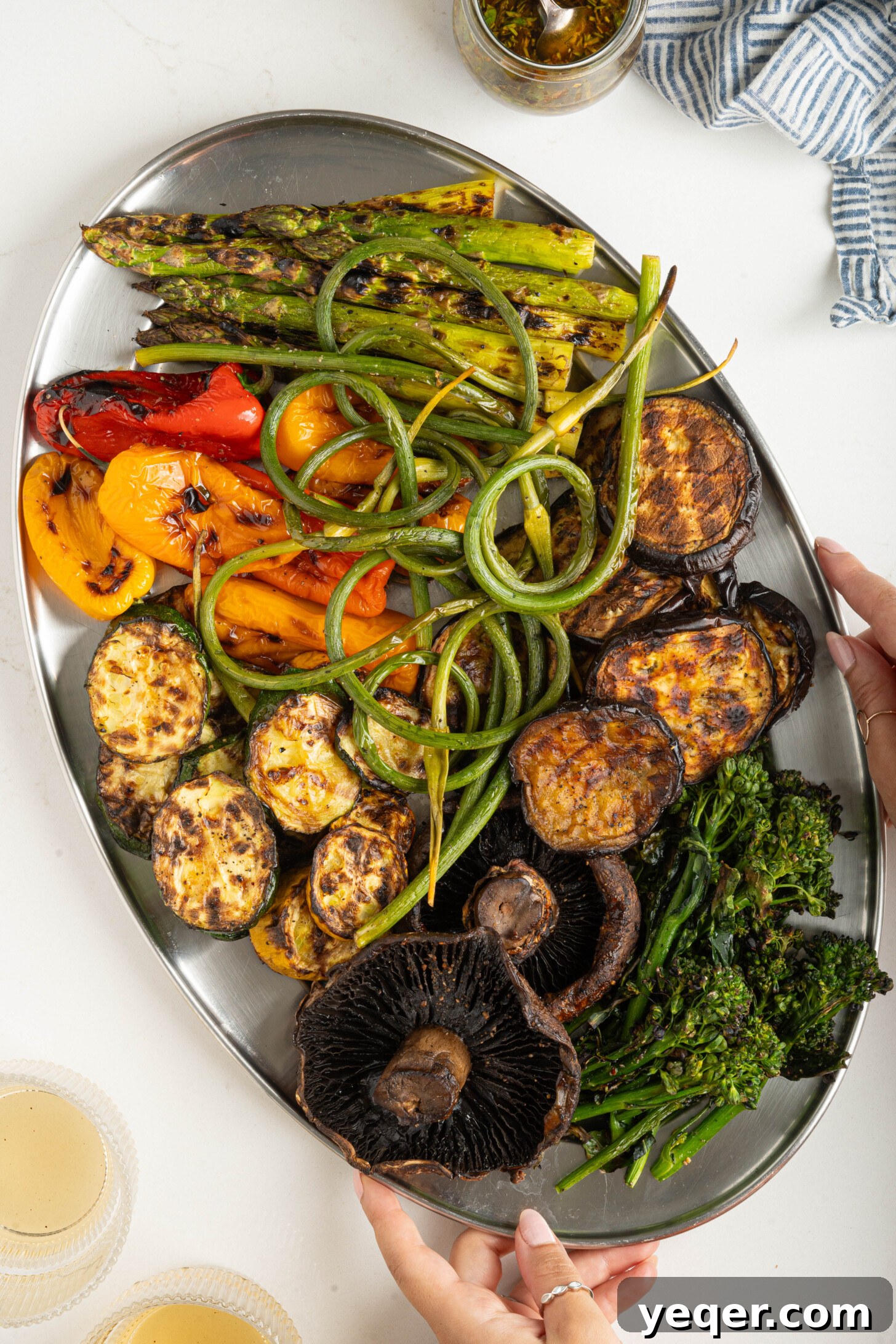 Effortless Grilled Vegetables: 3-Ingredient Marinade 12 Hands holding a large platter of colorful, freshly grilled vegetables, showcasing a bountiful harvest ready to be served.