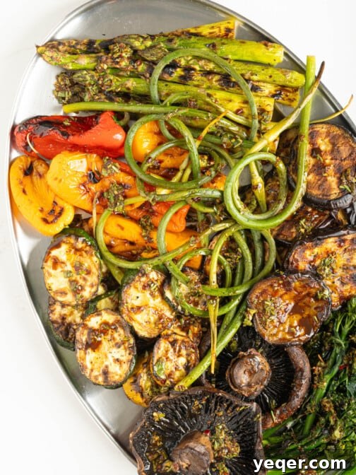A platter of perfectly grilled assorted vegetables, glistening with a light dressing and ready to be served.