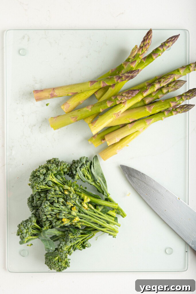 Effortless Grilled Vegetables: 3-Ingredient Marinade 6 Asparagus and broccolini laid out on a cutting board, with their ends chopped, preparing for grilling.